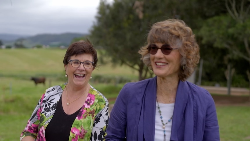 Maggie Dent and Geraldine Doogue laughing standing outside in a paddock