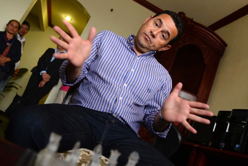 Guatemalan presidential candidate for the National Front of Convergence (FCN) party Jimmy Morales, gestures as he plays chess observed by journalists in Guatemala City