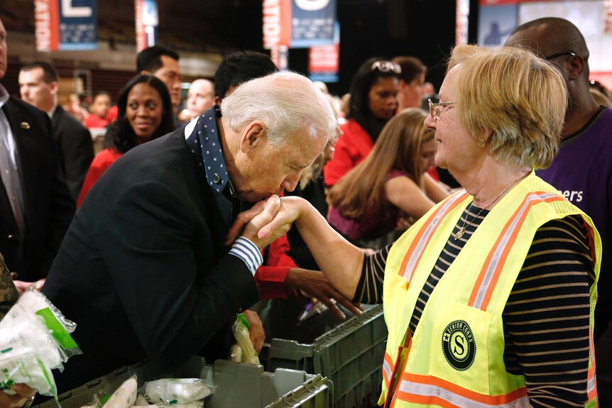 Former vice-president Joe Biden kisses a volunteer's hand on January 19, 2013.