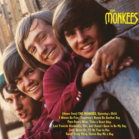 The album cover for The Monkees features all four members looking over each other's shoulders