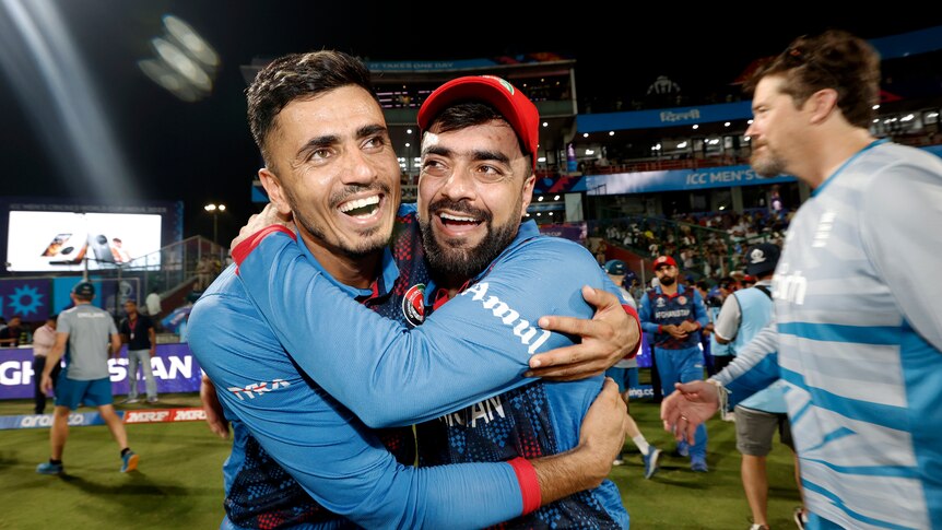 Two Afghan cricket players embrace after winning a cricket match