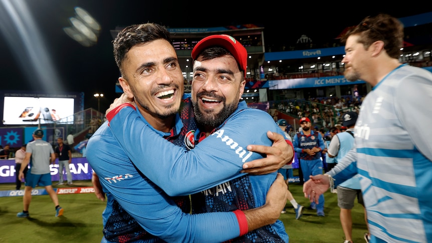 Two Afghan cricket players embrace after winning a cricket match