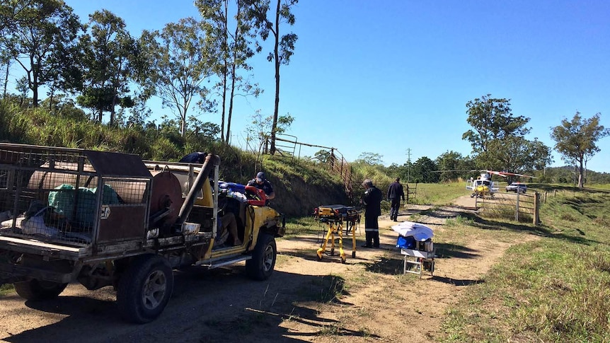 CQ Rescue chopper paramedics with a gurney near the truck of an injured farmer on a dirt road