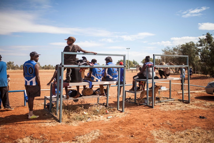 Spectators watch a footy game in Warakurna, WA.