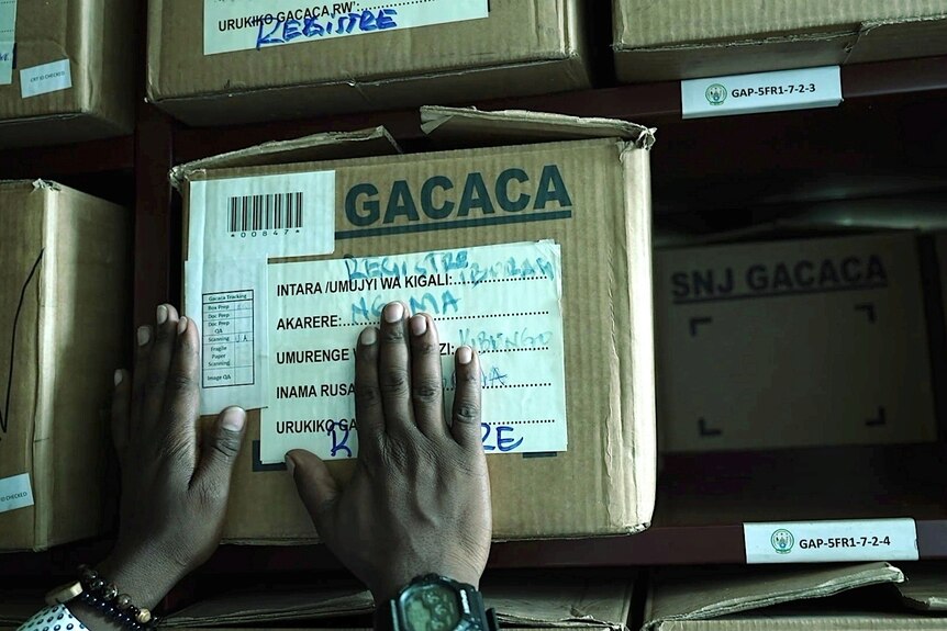 A pair of hands on a cardboard box labelled 'GACACA'. 
