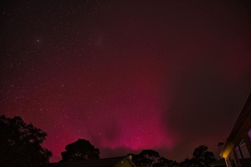 A glowing sky lit up by aurora australis.