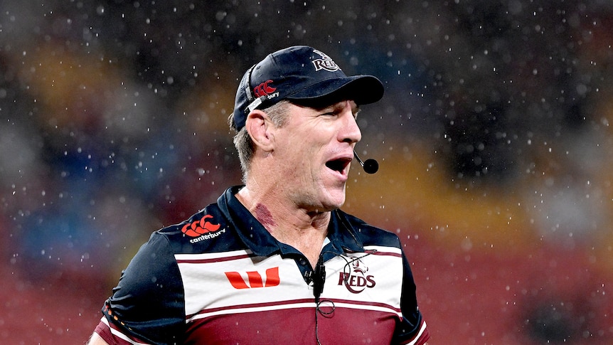 A rugby coach grimaces during a match