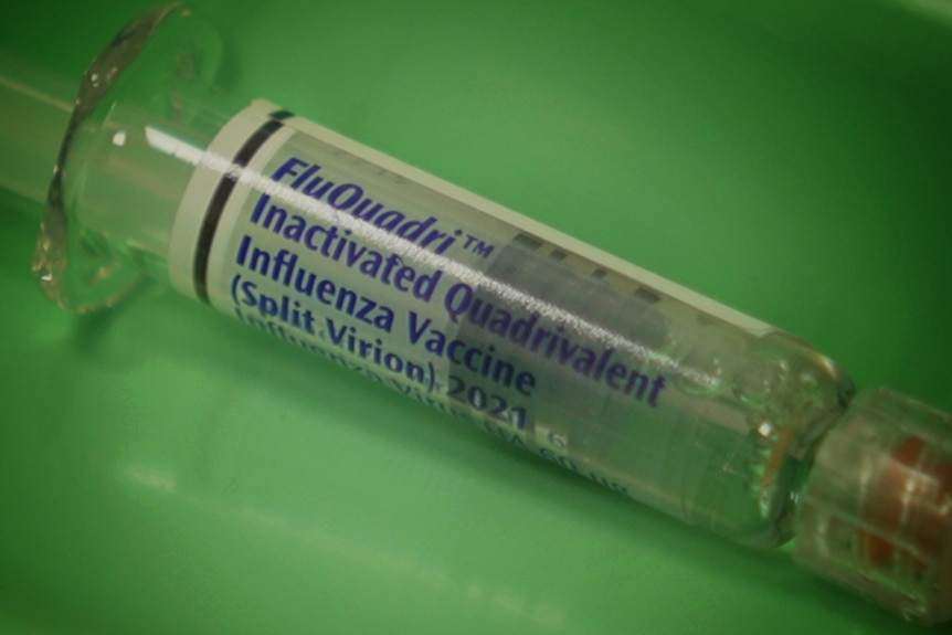 A close up of a flu vaccine vial in a tray