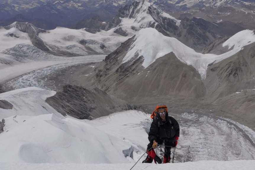 A man climbs up an icy mountain