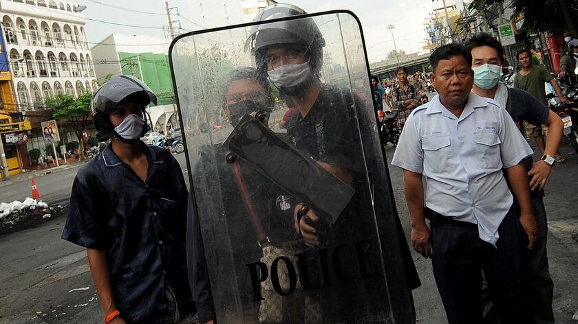 A Thai Red Shirt anti-government protester shields himself during ongoing clashes in Bangkok.