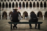 Stripey-shirted gondoliers chat as they wait for customers near St. Mark's square in Venice.