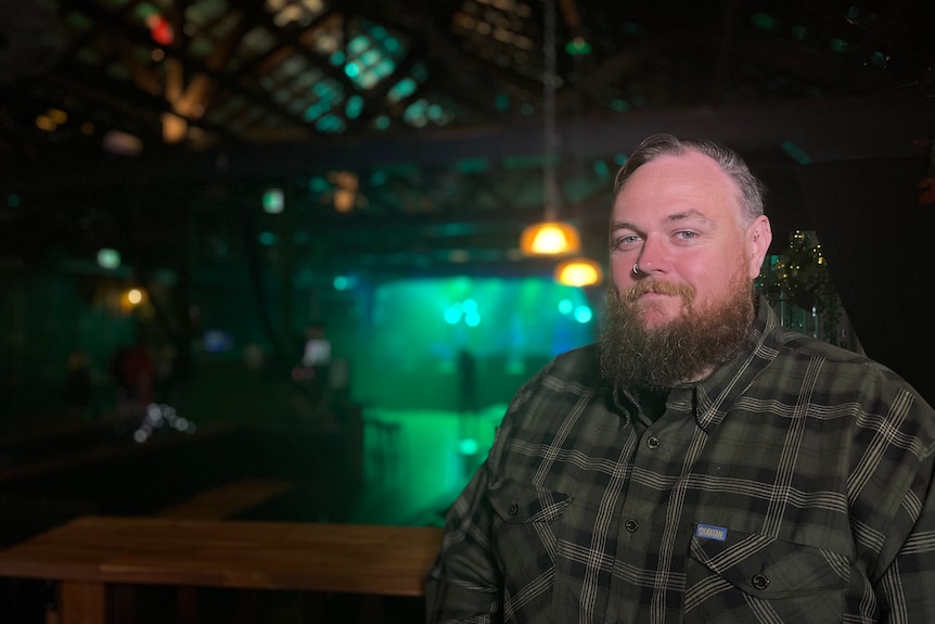 Luke Johnston stands next to a stage at The Zoo