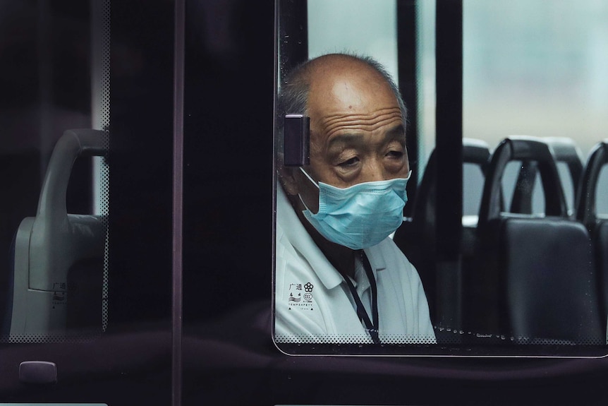 A man wearing a face mask to protect against the new coronavirus rides alone on a bus.
