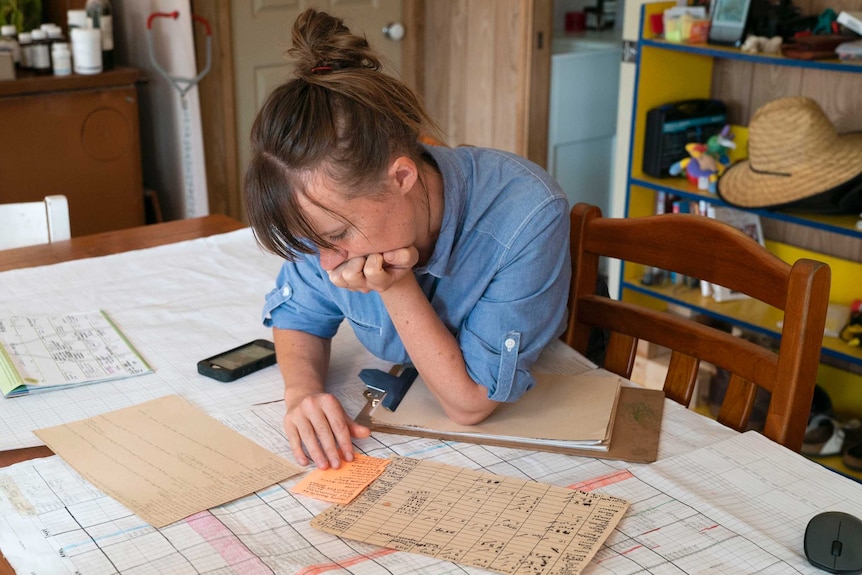 Emily Yarra looking at paperwork on kitchen table.