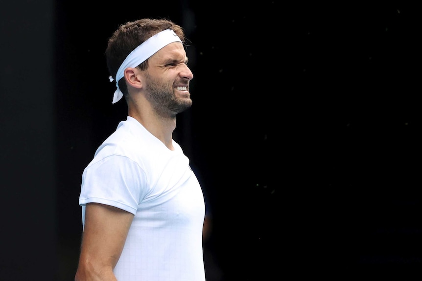 A tennis player grimaces in pain after a point in his men's singles quarter-final at the Australian Open.