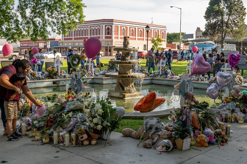 A woman lays flowers in memory of victims of a mass shooting