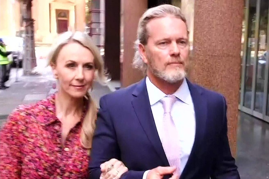 Vanessa Scammell and Craig McLachlan walk down the street arm-in-arm.