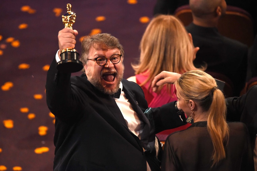 Guillermo del Toro holds up his award for best director for The Shape of Water.