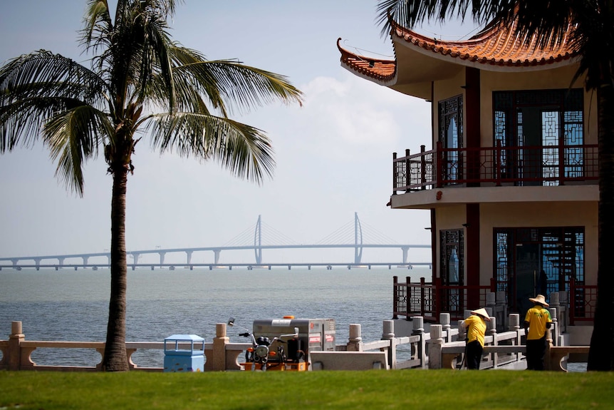 Workers clean a pavilion as the Zhuhai-Macau-Hong Kong Bridge