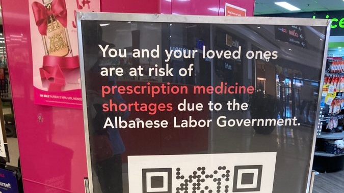 A poster in a pharmacy which says "you and your loved ones are at risk of prescription medicine shortages due to the government