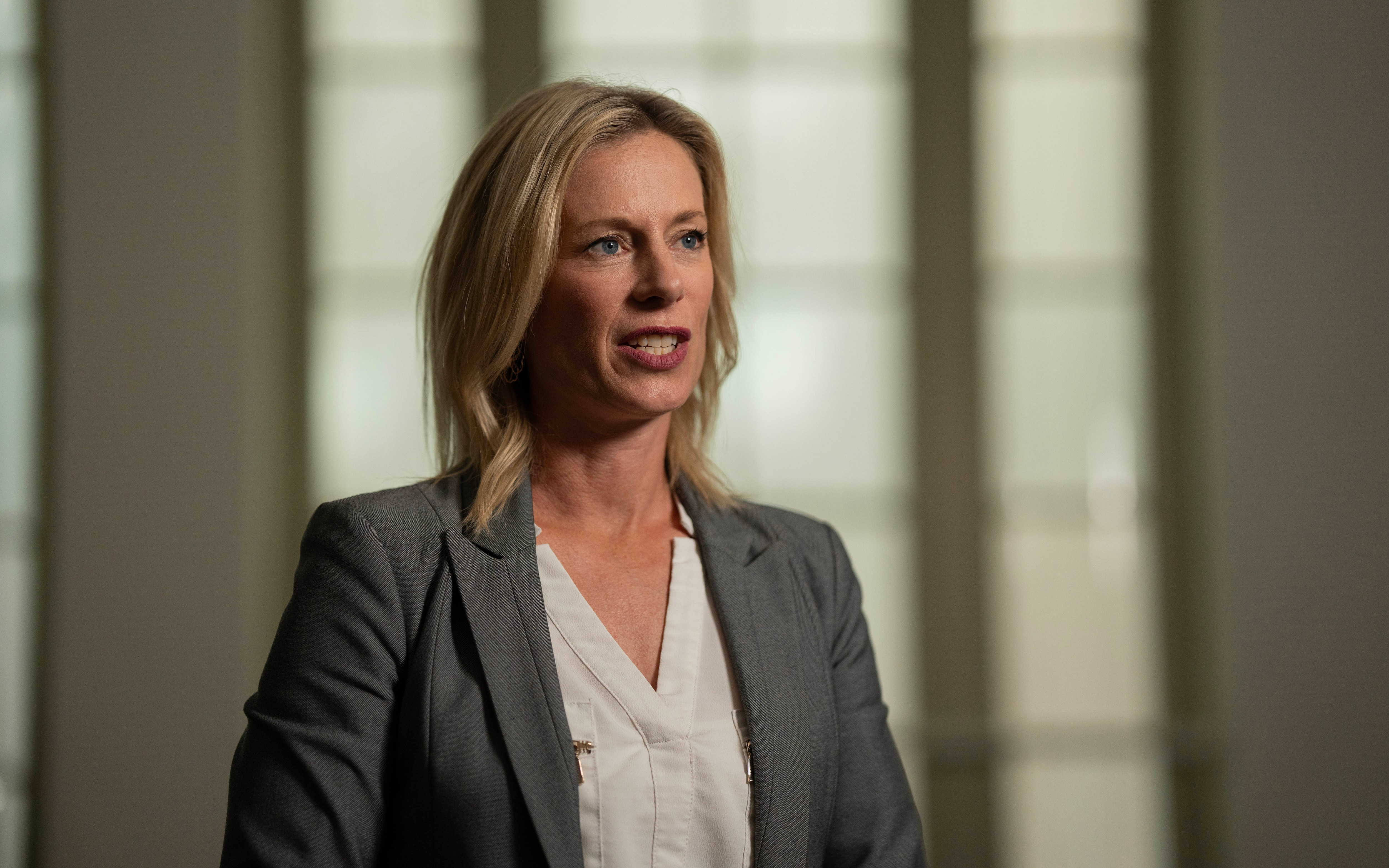 A female politician during an interview with a journalist surrounded by three cameras, microphones and a light.