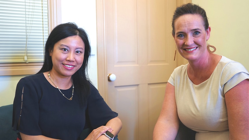 Two academics smiling while sitting in an office