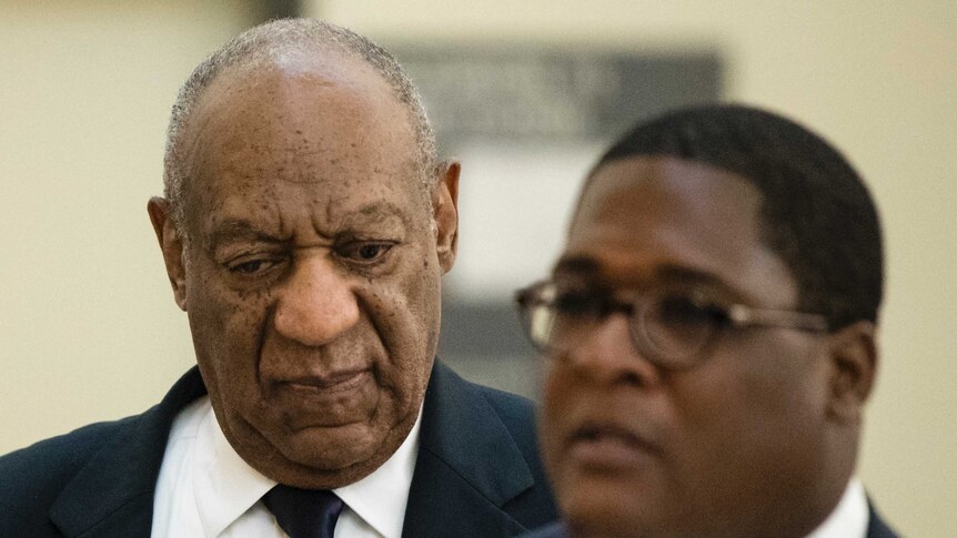 A closeup of Bill Cosby with his eyes down next to spokesperson Andrew Wyatt.