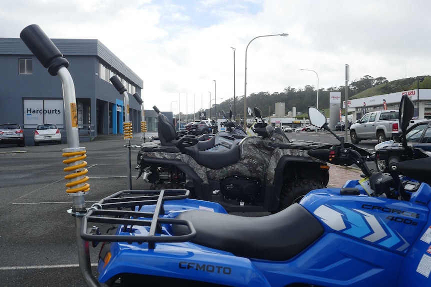 Quad bikes lined up in a dealership.