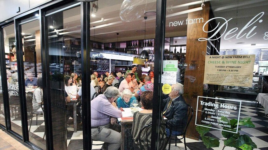 Patrons eat cheese and drink wine at the New Farm Deli