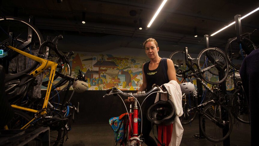 City of Sydney council deputy mayor Jess Miller pushes a bicycle into an indoor bicycle lock up area