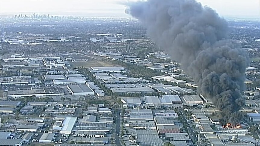 A wide shot shows a huge plume of smoke spiralling over Melbourne's northern suburbs