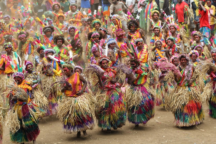 A large group of women dancing in an array of colours.