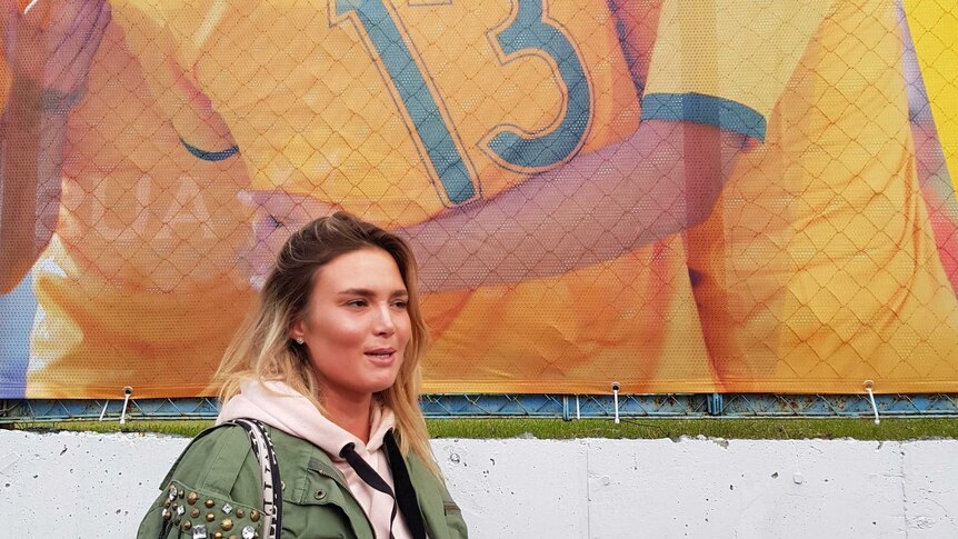 Woman stands in front of Socceroos poster in Kazan, Russia on June 11, 2018.