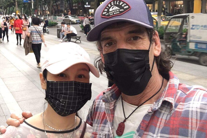 A close up photo of an Australian man and a Chinese woman wearing a face mask.