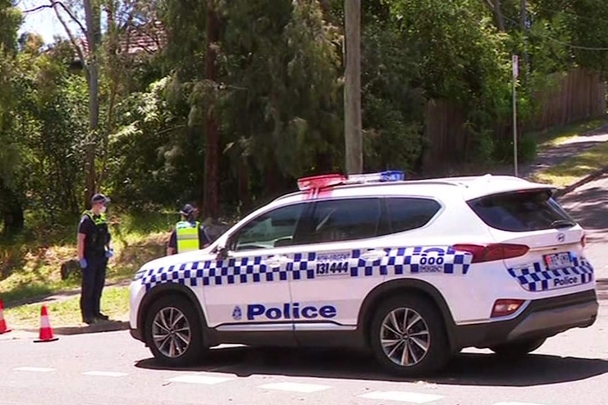 A police car beside some traffic cones at the entrance to a street in Greensborough.