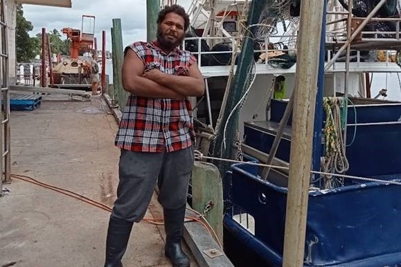 Eric next to a fishing boat.