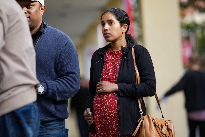 A close-up shot of Aishwarya Aswath's mother Prasitha Sasidharan with her husband partially visible standing next to her.