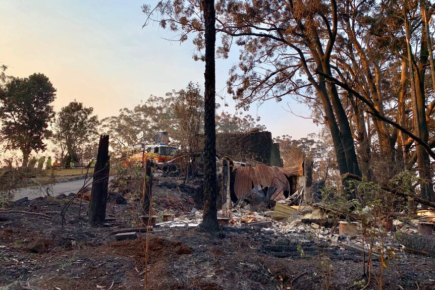 Ruins of Binna Burra Lodge after bushfires in the Lamington National Park, with a fire truck in background.
