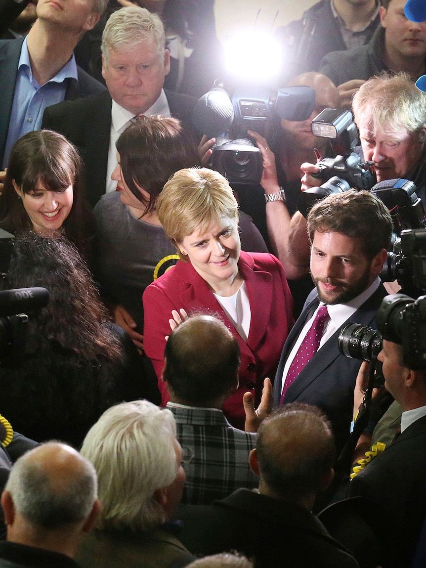 Scotland's First Minister Nicola Sturgeon is surrounded by photographers and journalists as she arrives in Glasgow.