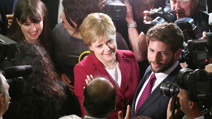 Scotland's First Minister Nicola Sturgeon is surrounded by photographers and journalists as she arrives in Glasgow.