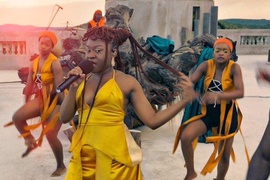 Women dancing, with Sampa at the front holding a microphone
