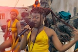 Women dancing, with Sampa at the front holding a microphone