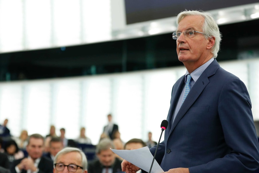European Union chief Brexit negotiator Michel Barnier stands at a podium to deliver a speech