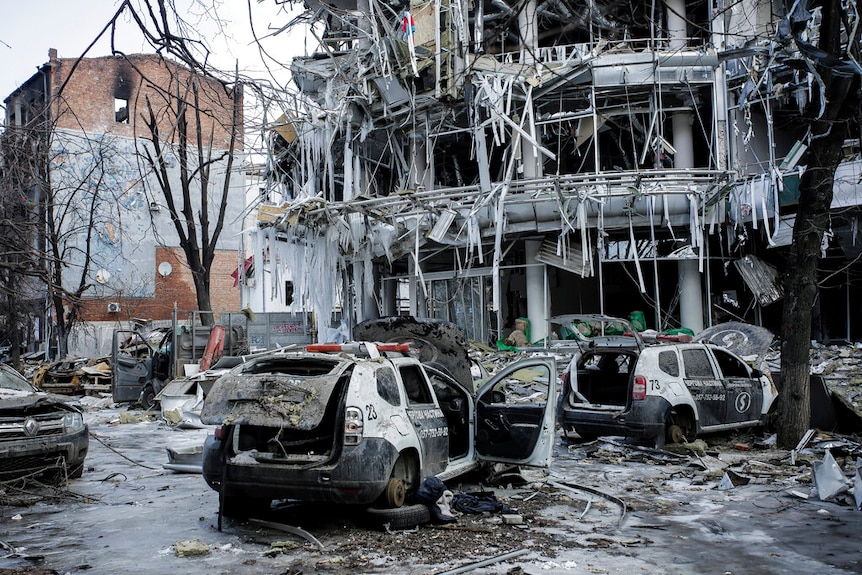 Bombed and burnt out cars and buildings.