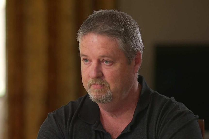 MCU of Rob Byrne, with grey hair and goatee beard, wearing a black polo shirt