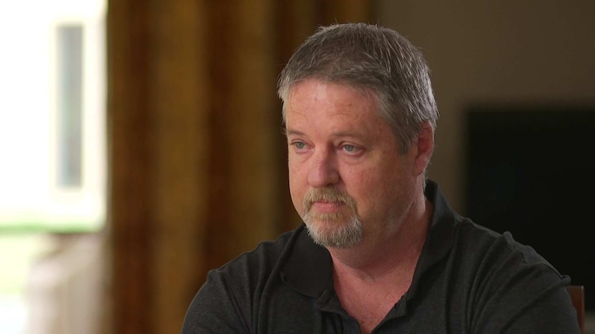 MCU of Rod Byrne, with grey hair and goatee beard, wearing a black polo shirt