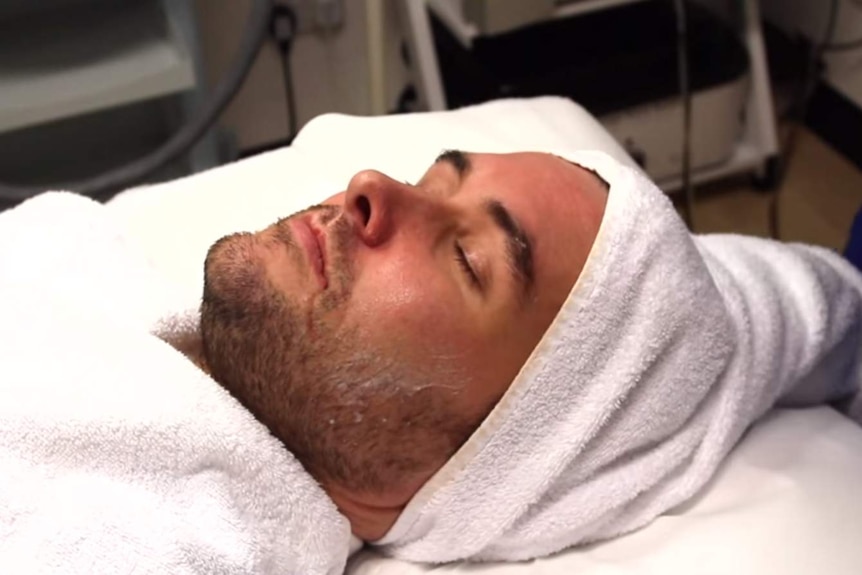 A man's face is prepared for a microdermabrasion treatment.