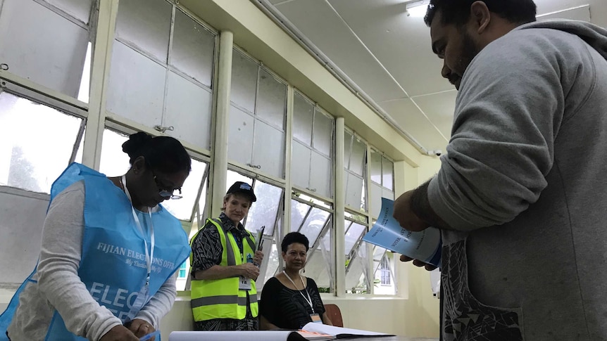 A voter lines up to have his name ticked off a roll in the Fiji election.