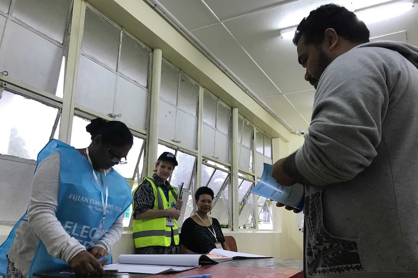 A voter lines up to have his name ticked off a roll in the Fiji election.