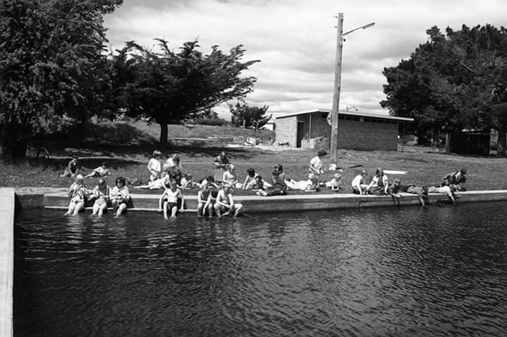 Black and white photo of people swimming in a river